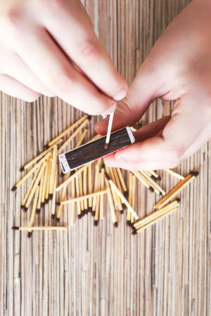 A child looks and plays with matches, a dangerous activity for a toddler at home.の写真素材