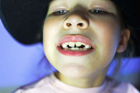 Girl in a black hat and black mask on a purple backgroundの写真素材