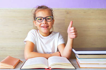 Schoolgirl girl reads books after school to know a lot.の写真素材