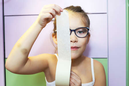 girl and white tape or duct tape, domestic violence in a home or apartment, discrimination and child abuse, fear and panic in the familyの写真素材