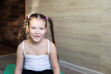 girl child in sportswear on a rubber gymnastic mat shows a healthy lifestyle, always having fun and in good shapeの写真素材