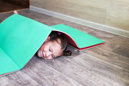 girl child in sportswear on a rubber gymnastic mat shows a healthy lifestyle, always having fun and in good shapeの写真素材
