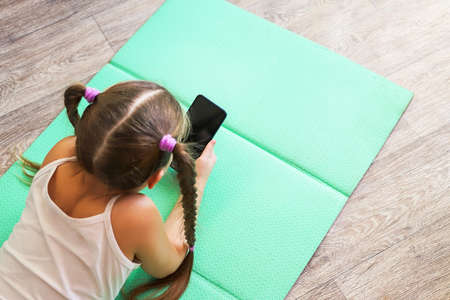 girl child with pigtails talking on the phone, getting homework on a cellular connection, during...