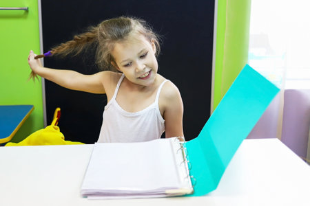 I don't want to study, distance education, a child girl pulls her hair in protest studies and lessonsの写真素材