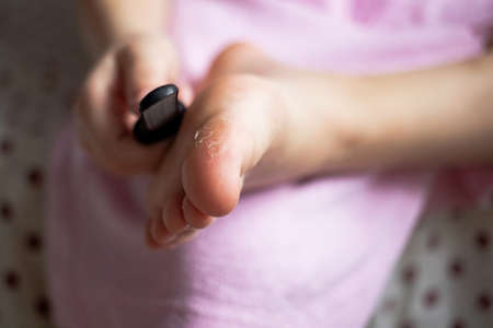 cleaning the foot with an abrasive stone for the toes, a health procedure after a shower bath for every day.の写真素材