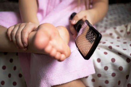 cleaning the foot and heel with an iron brush like a vegetable grater, health and beauty style after bath.の写真素材