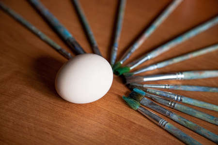 the brushes are laid out in a fan on the table, in the center, around the egg, ready for painting, a blank for the designer.の写真素材