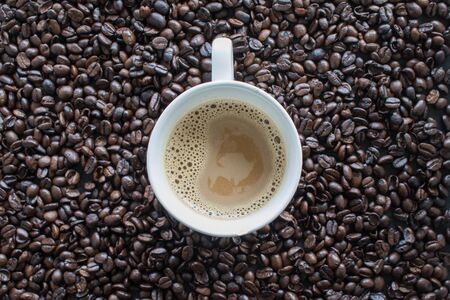 Top view of coffee cup on coffee beansの写真素材