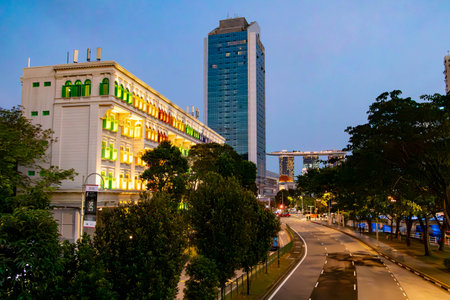 The Old Hill Street Police Station, with its vibrant rainbow-colored windows, contrasts beautifully against the modern elegance of the Marina Bay Sands Hotel in Singaporeの写真素材