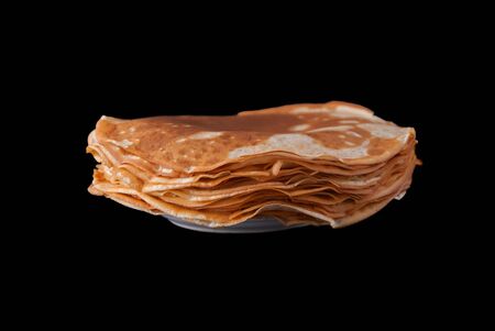 Russian pancakes pile on plate, isolated on black backgroundの写真素材