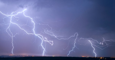 Many big lightning in the stormy sky over a cityの写真素材