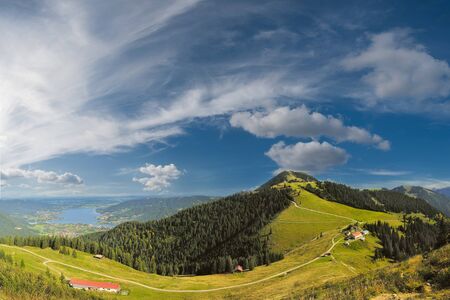 Beautiful panorama Alps mountains with lake in valley and clouds on backgroundの写真素材