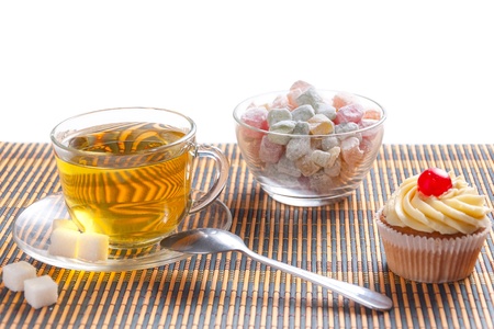 Green tea, fresh cherry muffin, colorful delight and sugarの写真素材