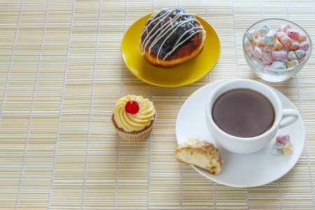 Tea, fresh cherry muffin, colorful delight, half eclair and doughnutの写真素材