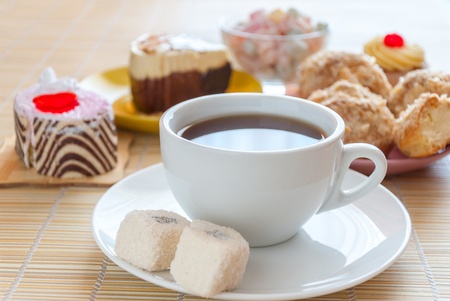Tea, fresh cherry muffin, colorful delight, eclair and doughnutの写真素材