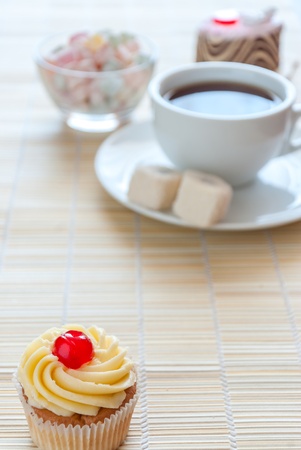 Tea, fresh cherry muffin, colorful delight and various cakeの写真素材