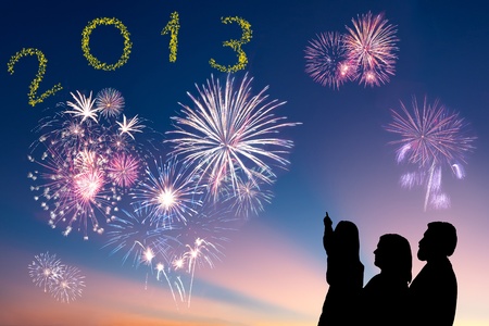 The happy family looks beautiful colorful holiday fireworks in the evening sky with majestic clouds,  long exposureの写真素材