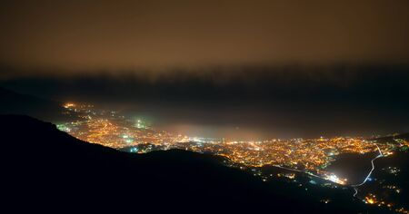 Night landscape from mountain top on the city on the seashore, panoramaの写真素材