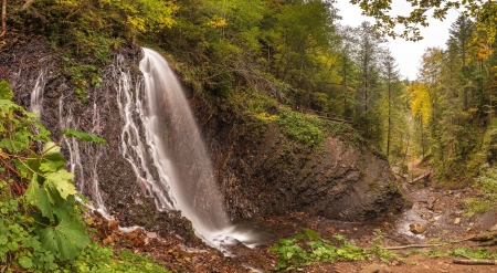 Autumn landscape with waterfall in the mountains