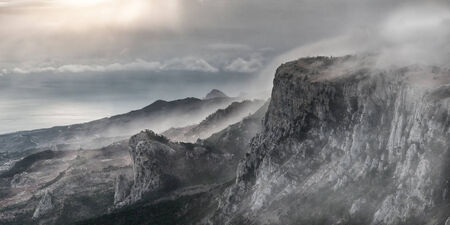 Surrealistic mountain landscape with peaks in mistの写真素材