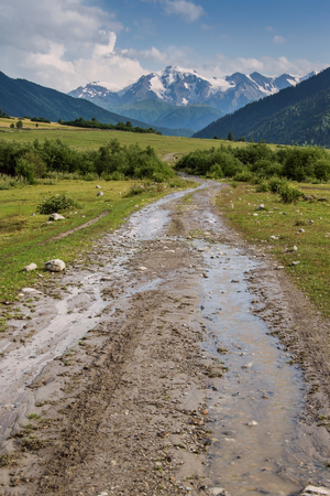 Road in valley after rain, mountains in the backgroundの写真素材