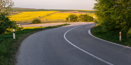 A winding road with tire tracks on the asphalt, a sharp turnの写真素材