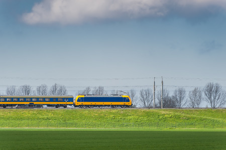 High-speed passenger train moving along green field