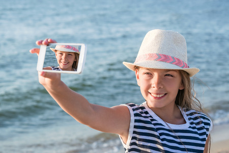 Cute teenage girl making a selfie on beach, summer vacation backgroundの写真素材