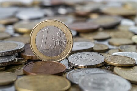 Coin one euro against background of other different coins, finance concept, selective focusの写真素材