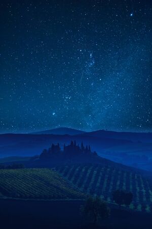 Night landscape with Tuscany valley and beautiful stars in skyの写真素材
