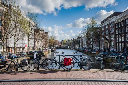 Bikes on bridge and embankment in Amsterdam, cityscape, Netherlandsの写真素材