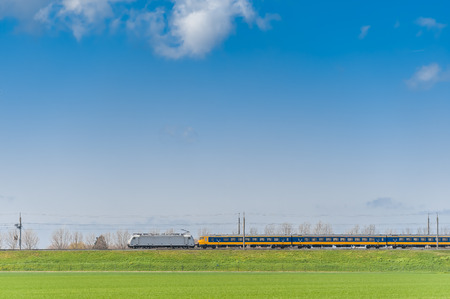 High-speed passenger train moving along green field. Transportation and travel theme. Railway transportのeditorial素材