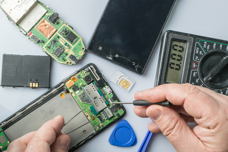 Broken cell phone repair. Smartphone parts and tools for recovery, selective focusの写真素材