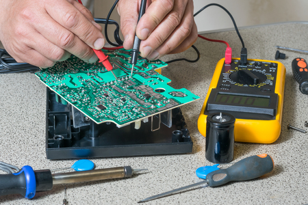 Electronics repair and metering parameters. Broken electronic board, professional repairmanの写真素材