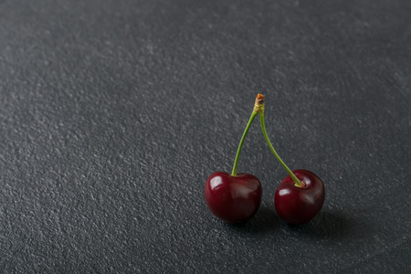 Sweet ripe cherries. Fresh cherry on black background. Farming abundanceの写真素材