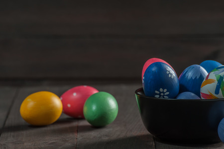Easter holiday background with painted eggs on wooden boards. Celebration decor, copy spaceの写真素材
