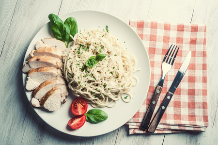 Italian spaghetti pasta with sauce and chicken, cheese parmesan and basil. Food background, flat lay. Film filter, retro styleの写真素材
