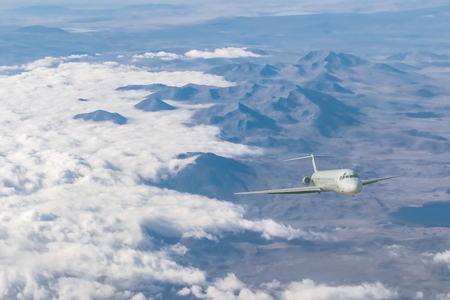 Landscape with commercial airplane flying above clouds. Passenger aircraft