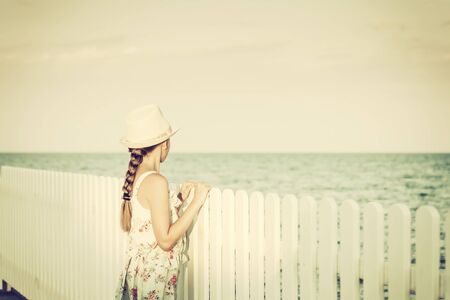 Cute white girl teenager resting on beach, summer view, selective focus. Vintage stylization, retro...