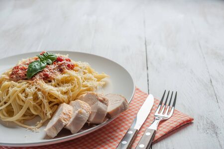 Italian spaghetti pasta with sauce and chicken, cheese parmesan and basil. Food background, selective focusの写真素材