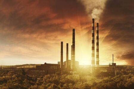 Industrial landscape with smoke from pipes in old factory on sunset, ecology catastrophe and climate change. Retro stylization, vintage film filterの写真素材