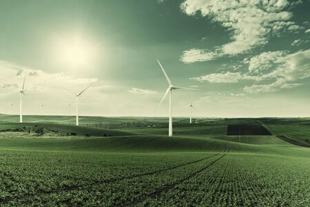 Industrial landscape with wind turbines in field, renewable eco energy, electric windmills. Retro stylization, vintage film filterの写真素材