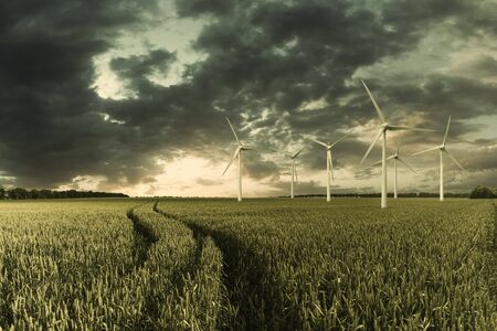 Industrial landscape with wind turbines in field, renewable eco energy, electric windmills. Retro stylization, vintage film filterの写真素材