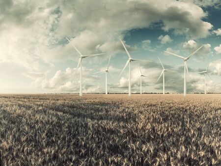 Industrial landscape with wind turbines in field, renewable eco energy, electric windmills. Retro stylization, vintage film filterの写真素材