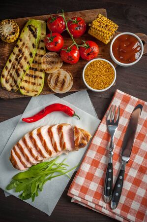 Fried pork fillet and grilled vegetables, delicious barbecue dinner, flat lay food backgroundの写真素材
