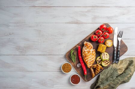 Fried chicken fillet and boiled vegetables, delicious barbecue dinner, flat lay food backgroundの写真素材
