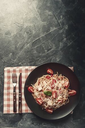 Italian spaghetti pasta with sauce and chicken, cheese parmesan and basil. Food background, flat lay. Retro stylization, vintage film filterの写真素材