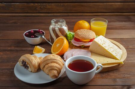 Breakfast with tea, orange juise and croissant on wooden rustic boards. Food background, copy spaceの写真素材