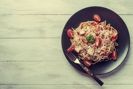 Italian spaghetti pasta with sauce and chicken, cheese parmesan and basil. Food background, flat lay. Retro stylization, vintage film filterの写真素材
