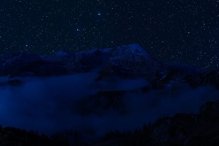 Night landscape with majestic mountains and stars in sky, mountaineering and climb background